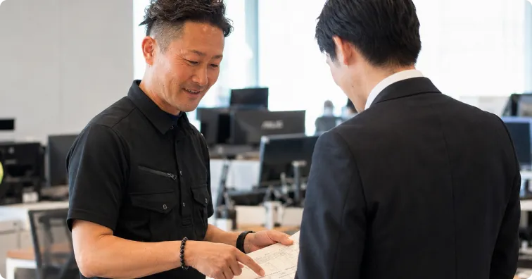 オフィスで見積りを説明する担当者と依頼者