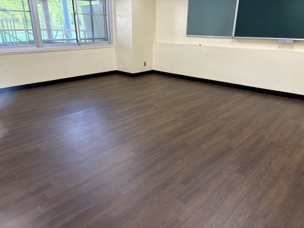 酒々井町の私立学校食堂でフロアタイルを施工している様子