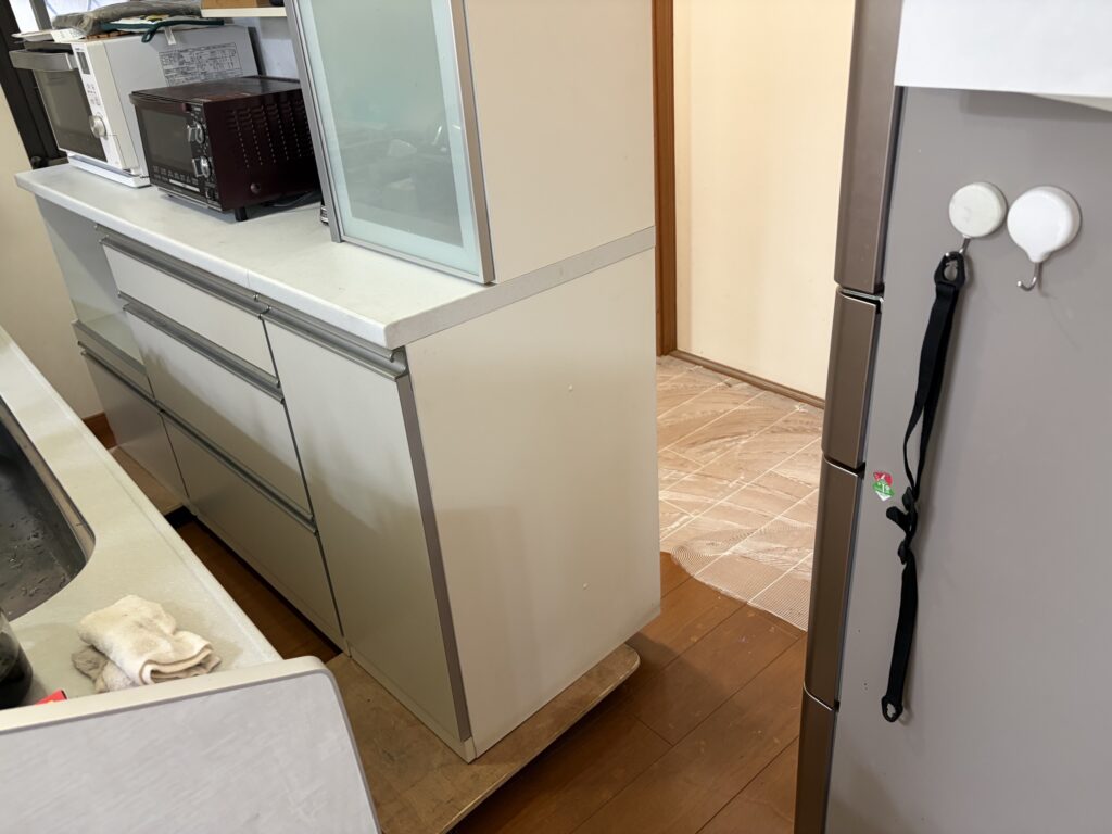 部屋の形状に合わせてフロアタイルをカットし端部を施工している様子
